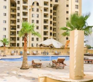 a resort with palm trees and chairs and a pool at Modern Oasis in Heart of Marina with Marina View - 11AB05 in Dubai