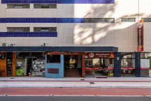 a store with a blue door on a city street at Apto quadra mar c/varanda ESA901 in Balneário Camboriú