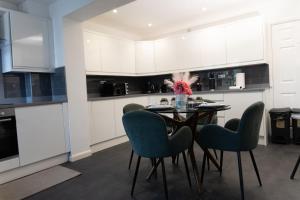 a kitchen with a table and four chairs at Spacious 4 Bed Home in Milton Keynes -free parking in Milton Keynes