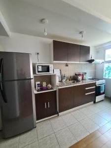 a kitchen with brown cabinets and a stainless steel refrigerator at Belgrano Ushuaia in Ushuaia