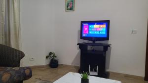 a television sitting on a stand in a living room at Cozy Apartment Ennasr in Ariana