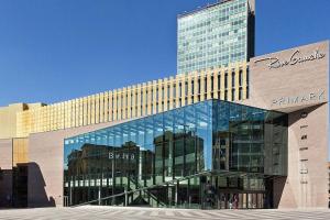 a large glass building with a tall building at Rive Gauche A centre - gare - aéroport in Charleroi