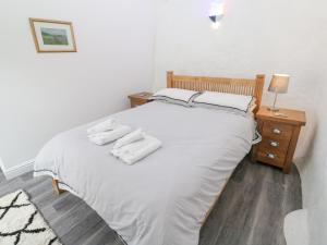 a bedroom with a bed with white sheets and pillows at Toadstools in Penryn