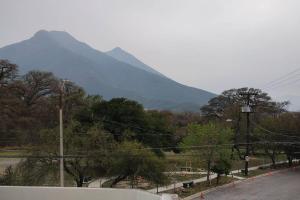 uma montanha à distância com uma estrada e árvores em Departamento muy cómodo y muy bien ubicado. zona contry, pastora, estadio bbva em Monterrey