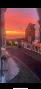 a sunset in a town with a building and a street at 2 Bedroom Luxury Apartment Prince Street Bridlington Sleeps 5 in Bridlington