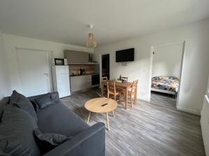 a living room with a couch and a table at Les jardins du Moiron in Le Champ-près-Froges