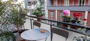 einen Tisch und Stühle auf einem Balkon mit Topfpflanzen in der Unterkunft Casa RA in Bari