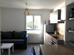 a living room with a couch and a kitchen at Les jardins du Moiron in Le Champ-près-Froges