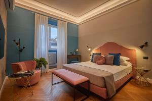 um quarto com uma cama grande e uma cadeira em Santarosa Rooms em Florença