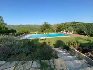a swimming pool in a garden next to a field at Villa Rignana - Chianti Weddings in Greve in Chianti