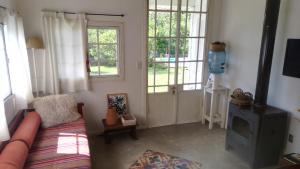a living room with a couch and a door with windows at Chalet Las Doritas in La Cumbre