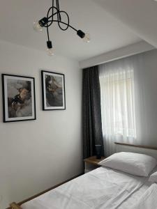 a bedroom with two beds and a chandelier at Dom na Borówkowym Wzgórzu in Paleśnica