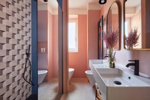 a bathroom with a sink and a toilet and a mirror at Santarosa Rooms in Florence +34 photos