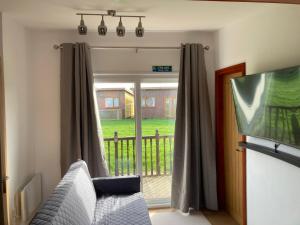 a living room with a couch and a sliding glass door at G10 Rickardos Holiday Lets in Mablethorpe