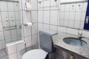 a bathroom with a toilet and a sink at Pousada Suiça in Santa Leopoldina
