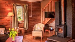 una sala de estar con estufa de leña en una cabaña en The New Farmhouse en Biggar