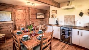 a kitchen with a table with chairs and a stove at The New Farmhouse in Biggar