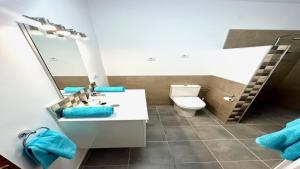 a bathroom with a toilet and a sink and a mirror at Maya Powered by SolymarCalma in Costa Calma