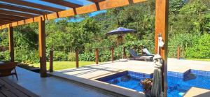 um pátio com um guarda-sol e uma piscina em Paraíso no Rocio na Reserva Florestal de Araras em Petrópolis
