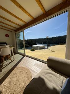 un soggiorno con una grande finestra scorrevole in vetro di Castelo de Bode - Lake House, A Casa do Avô a Levegada