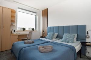 1 dormitorio con 2 camas y sábanas azules en Sapphire Room Hotel Lechicka en Poznan