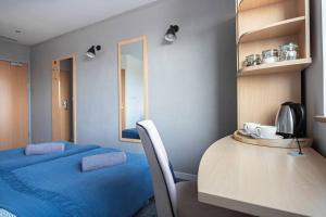 a room with a bed and a table and a mirror at Sapphire Room Hotel Lechicka in Poznań
