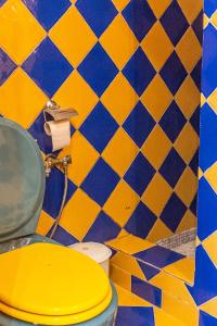 アテネにあるTsilo Cozy Apartの黄色のタイル張りのバスルーム(黄色のトイレ付)