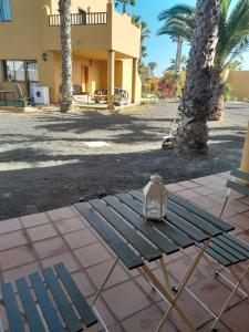 a picnic table with a lantern sitting on it in front of a house at Casa Damar in Corralejo