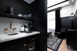a black kitchen with a sink and a living room at The Dorchester Hotel in Collingwood