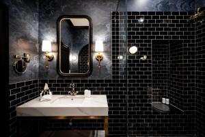 a bathroom with a white sink and a mirror at The Dorchester Hotel in Collingwood