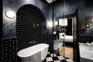 a bathroom with a tub and a black and white tiles at The Dorchester Hotel in Collingwood