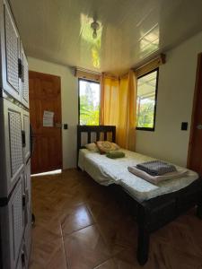 Habitación pequeña con cama y puerta en Vimanas Surf Shack, en Talamanca