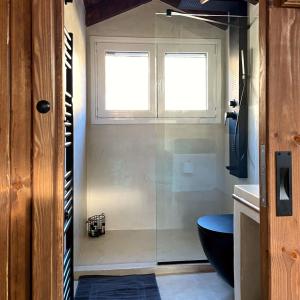 a bathroom with a shower and a toilet and two windows at Memories Apartments Μονοκατοικία στο Καρπενήσι in Karpenisi