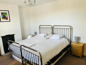 a bedroom with a bed and a chandelier at Bodhi Tree Cottage - Grove Road Cottages in Stratford-upon-Avon