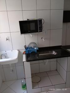 a small kitchen with a sink and a microwave at Pé na Areia in Rio de Janeiro