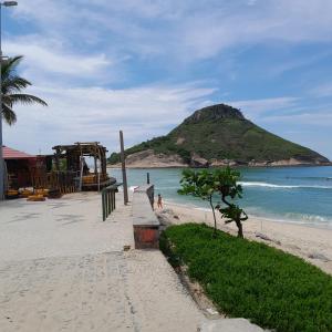 a beach with a playground and a mountain in the background at Pé na Areia in Rio de Janeiro