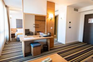 a hotel room with a desk and a bed at Hotel Avenue - Avenue Hotels in Buzău