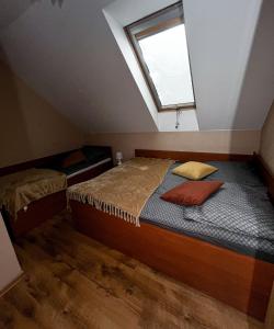 a attic bedroom with a bed and a window at Zielona Zagroda in Borek