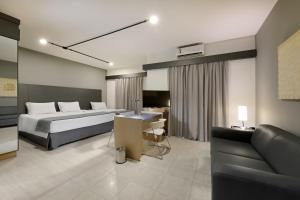 a bedroom with a bed and a desk and a couch at Araucaria Plaza in Ribeirão Preto