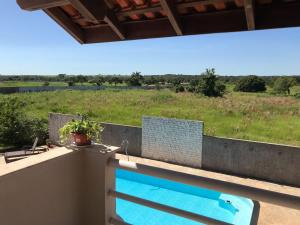 una piscina en un balcón con vistas a un campo en Pousada Encantos do Roncador en Barra do Garças