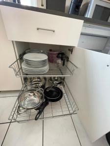 uma prateleira numa cozinha com pratos e panelas em Appartement mitten in der Stadt em Mönchengladbach