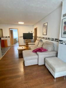 a living room with a white couch and a tv at Zur Auguststadt in Wolfenbüttel