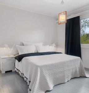a white bedroom with a white bed and a window at Tranquil Haven Villa in Ålesund