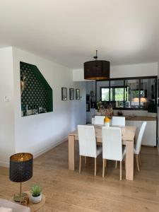 a dining room with a table and white chairs at Villa Jasmin in Gradignan