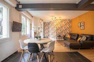 ein Wohnzimmer mit einem Tisch und einem Sofa in der Unterkunft Le Berthelot Saint Roch Appart City Gare in Montpellier