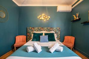 Schlafzimmer mit einem Bett mit blauen Wänden und orangefarbenen Stühlen in der Unterkunft Le Berthelot Saint Roch Appart City Gare in Montpellier