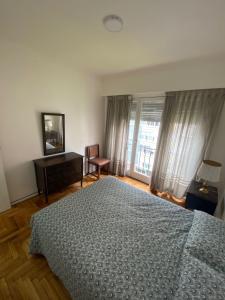 1 dormitorio con cama, escritorio y ventana en Check and Home - Gascón - 4 huéspedes al frente en el centro en Mar del Plata
