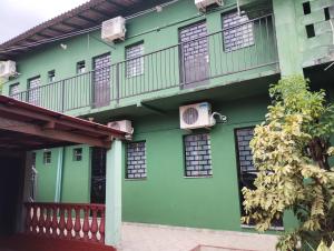 een groen gebouw met ramen en een balkon bij Residencial Andréa House in Manaus