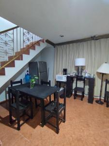 a living room with a table and chairs and a staircase at Hostal Ixchel - WiFi, Hot Water, AC, in Valladolid Downtown in Valladolid
