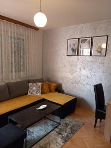 ein Wohnzimmer mit einem Sofa und einem Tisch in der Unterkunft Apartman Central in Bijeljina